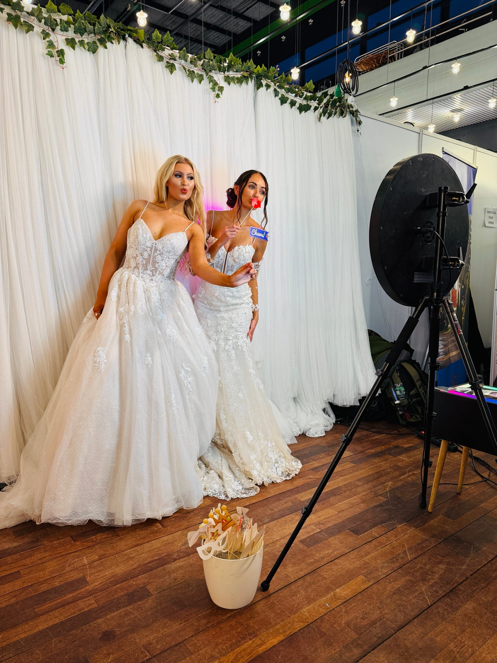 Two brides posing with props in front of SelfieCircle